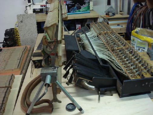 6 - Piano action & Upper player components on workbench for inspection 6 - Piano action & Upper player components on workbench for inspection